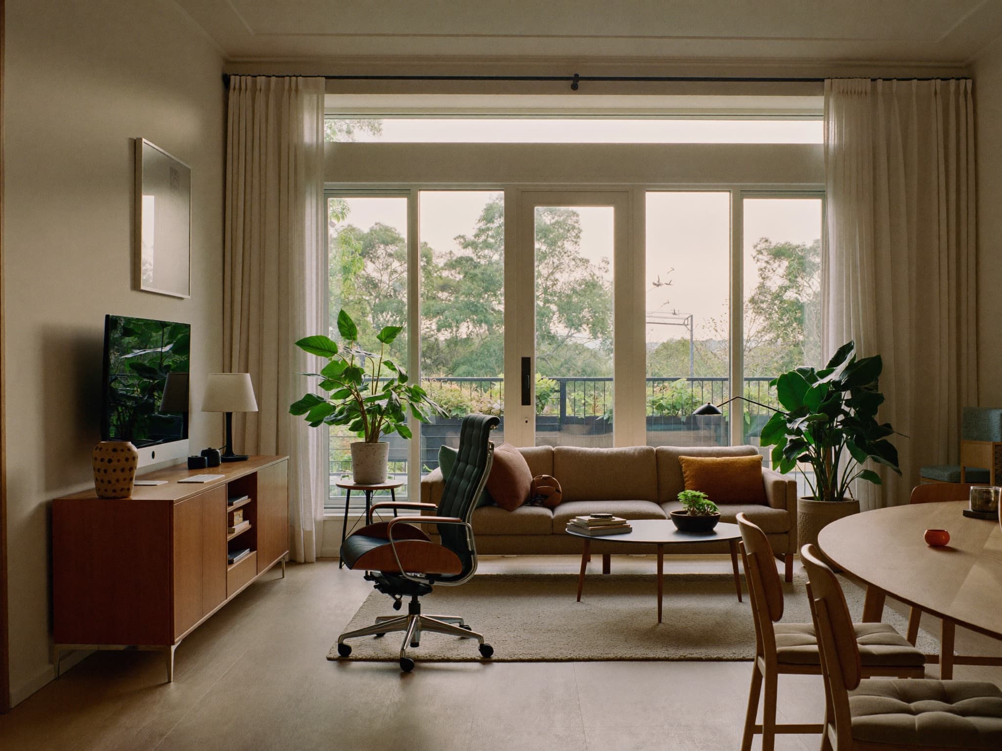 Bright, welcoming office lounge with a cozy sofa and green plants
